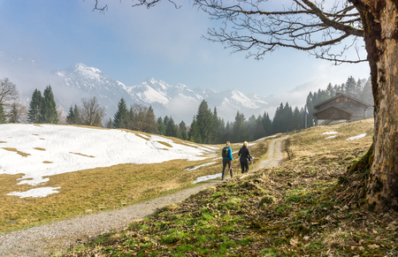 Two women hiking together in the mountains. Reaching mountain hut.の写真素材