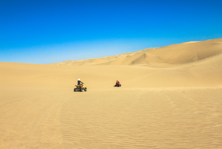 Quad driving people - two happy bikers in sand desert.の写真素材