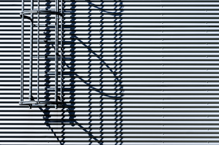 Corrugated metal wall with fire escape ladder.の写真素材