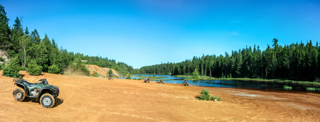 People driving ATV quads on sand beach at lakeの写真素材