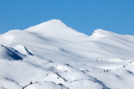 Two ski hikers walking towards summit cross. Sunbeams and backlight.の写真素材