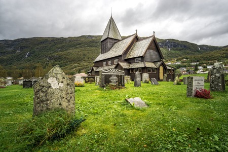 Stave church and cemetery of Roldal in dramatic light on a rainy moody day. Norway.の写真素材