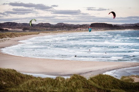Kitesurfing men in action on stormy sunset evening at Brusand Beach, Norway.の写真素材
