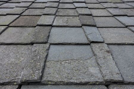 Old roof slate tiles roof with blue sky and clouds.の写真素材