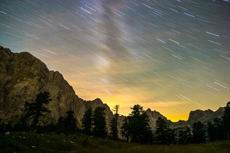 Star trails night sky at twilight hour. Julian Alps, Triglav National Park, Slovenia, Mountain View from Mount Slemenova, Sleme to Mountain Jalovec.の写真素材