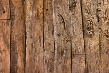 Natural brown barn wood wall. Wall texture background pattern. Wood planks, boards are old with a beautiful rustic look, style and woodworm holes.の写真素材