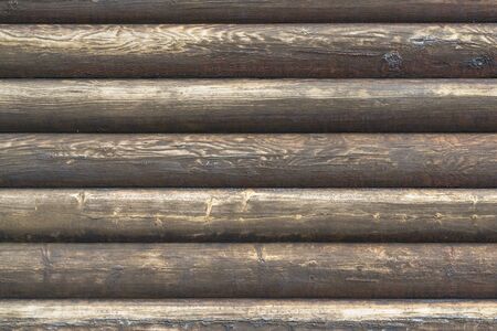 Natural brown log cabin wood wall. Wall texture background pattern. Wood planks, boards are old with a beautiful rustic look, style. Wall of Stave Church in Norway.の写真素材
