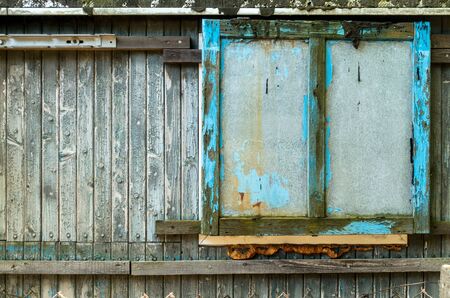 Old grungy closed Window Shutter Wall of Cabin.