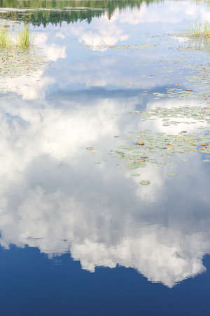 Blue mirror lake reflections of clouds and landscape. Sudbury, Ontario, Canada.
