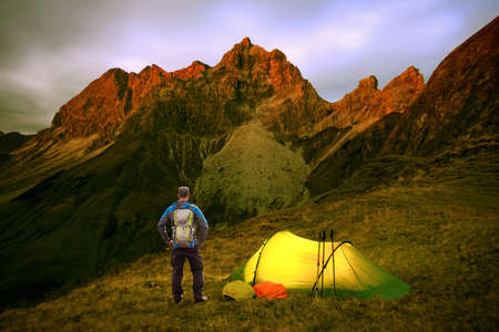 Hiker Man with Backpack and Tent enjoying Alpenglow at the mountain Grosser Wilder in Bavarian Alps, Allgau, Germany.の写真素材