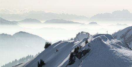 Snow Mountains Panorama in low lying inversion valley fog. Silhouettes of foggy Mountains. Scenic snowy winter landscape. View from Stuiben to Saentis. Alps, Allgau, Bavaria, Germany.の写真素材