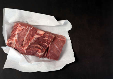 Meat on white paper, dark background.の写真素材