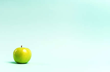 Green apple on a blue background. Copy space. Horizontal orientation .High quality photoの写真素材