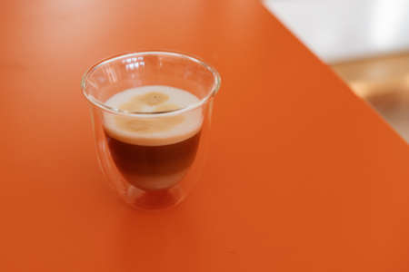 Coffee mug on an orange tableの写真素材