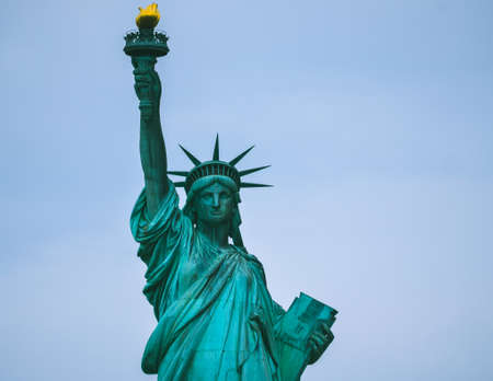 Close-up photograph of the Statue of Liberty. Shot is of upper torso with blue skies.の写真素材