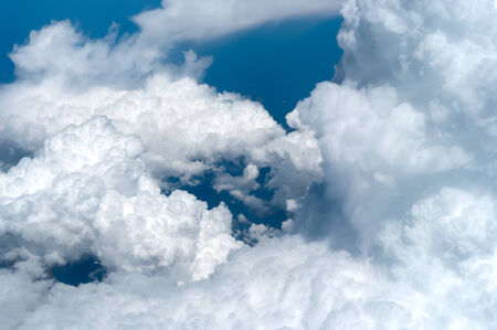 View of clouds as taken from above while flying over in a jet 