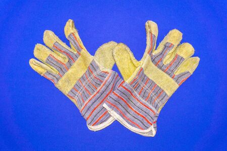 Protective worker gloves on a blue background