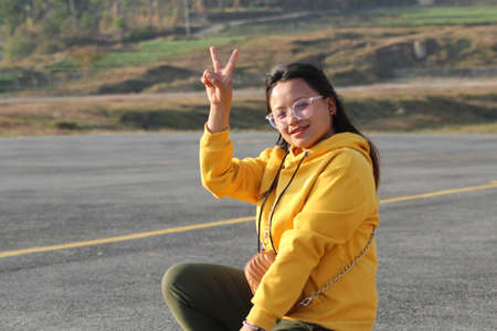 beautiful girl showing her hand gesture in front of yellow line with latest attractive fashion wear...