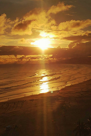 A beautiful sunset on a busy beach on the coast.の写真素材