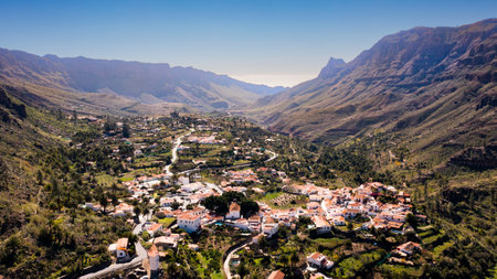 Landscape photo of city in the mountains. White houses, green mountains, valey between mountains. No clouds, daylight,の写真素材