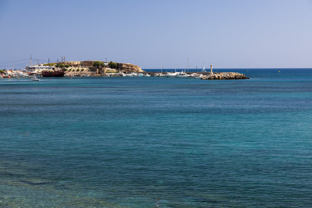 Experience the tranquility of a sunny day in Hersonissos port, where ships rest against the backdrop of the endless sea, offering a peaceful escape during your vacation journey.の写真素材