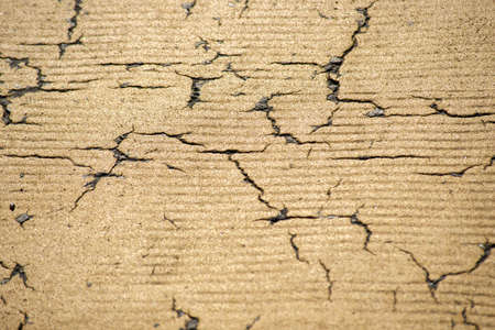 Yellow cracked paint on the ground (background)の写真素材