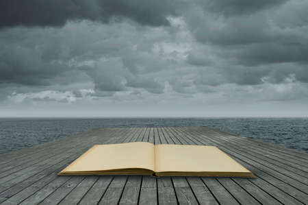 old book on wooden floor at waterの写真素材