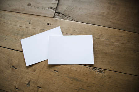 top view of white postcard or papers on old wooden background