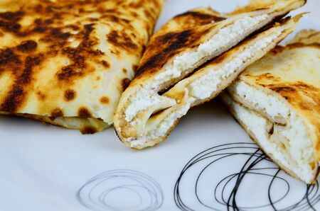 Pancakes with white cheese stuffed on plate