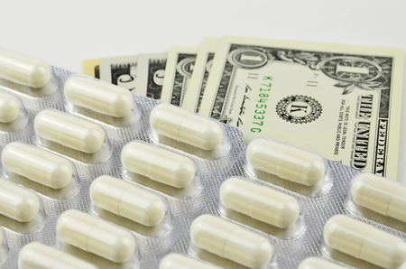 US Dollars and pills shows that the medicaments  are very expensiveの写真素材