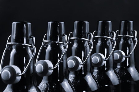 Empty beer bottles  stand straight up in one row, black and whiteの写真素材