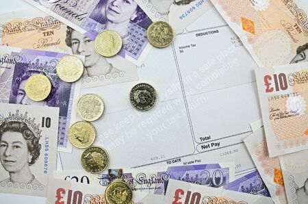 payslip with british  banknotes and coinsの写真素材