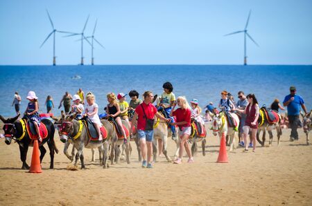 Skegnes-England July-2016 photo taken on the beach shows children riding on donkey with supervisor. Editorial photoのeditorial素材