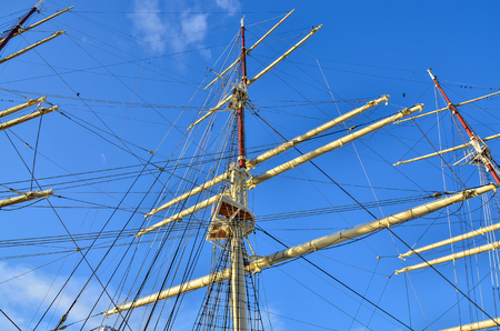Crows nest, mast, and canvas sails can be seen in this closeup detail of an old time tall wooden sailing ship.の写真素材