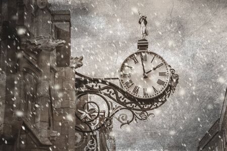 An old vintage clock  fixed to wall in snowing timeの写真素材