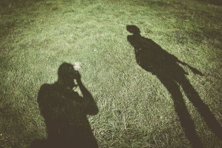 Shadow of photographer taking photo of tourist with dog on leadの写真素材