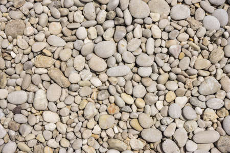 Abstract background of white pebbles stones arranged on the beach