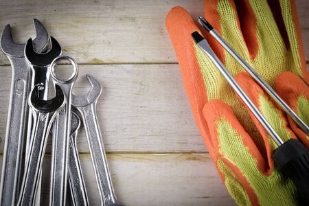 The different forms of screws and a wrench with nuts and gloves, with vignette effect