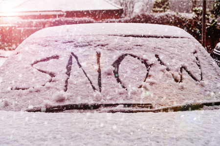 Snow covered car windscreen with the word snow written in the snowの写真素材