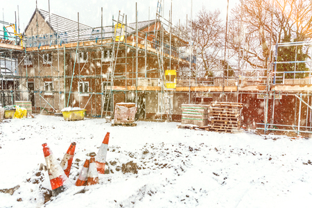 Construction site building a new brick home during winter time, snowing conditionsの写真素材
