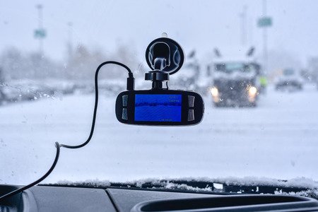 A car dash cam mounted on the front windshield recording the traffic ahead