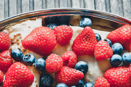 Pancake with summer fruits on wooden backgroundの写真素材