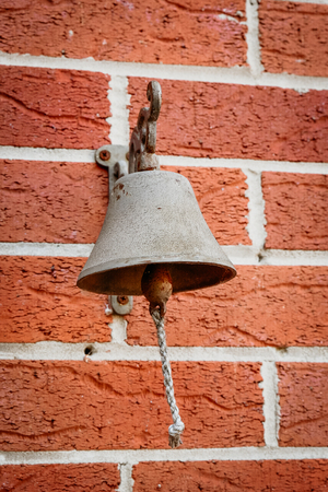 Antique brass bells strung hanging on the wallの写真素材