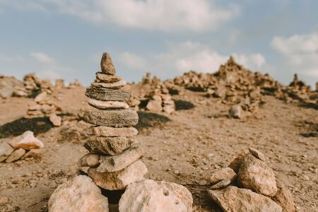 Tower of rocks on beach. Small Zen out of pile of stones on rock. Tombs of Kings, an ancient necropolis in Paphos, Cyprusの写真素材