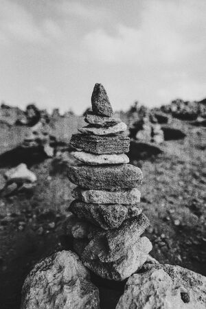 Tower of rocks on beach. Small Zen out of pile of stones on rock. Tombs of Kings, an ancient necropolis in Paphos, Cyprus, B&Wの写真素材