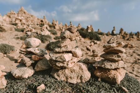 Tower of rocks on beach. Small Zen out of pile of stones on rock. Tombs of Kings, an ancient necropolis in Paphos, Cyprusの写真素材