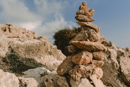 Tower of rocks on beach. Small Zen out of pile of stones on rock. Tombs of Kings, an ancient necropolis in Paphos, Cyprusの写真素材