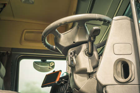 Underneath view of open cab interior big truck with steering wheel on front