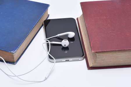A set of books being played as audio through the headphone speakersの写真素材