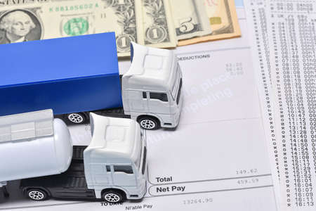 A lorry toys, payroll with dollar bill and face mask in concept about transport departament against coronavirus pandemic.の写真素材
